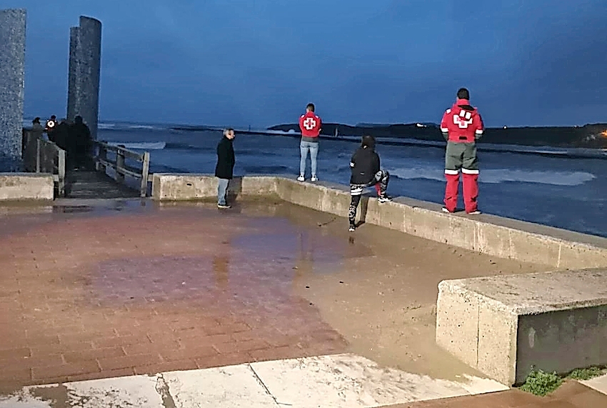 Varias personas observan el agua durante las labores de b&uacute;squeda del hombre que, seg&uacute;n un testigo presencial, cay&oacute; al mar en Suances. / g. cantabria