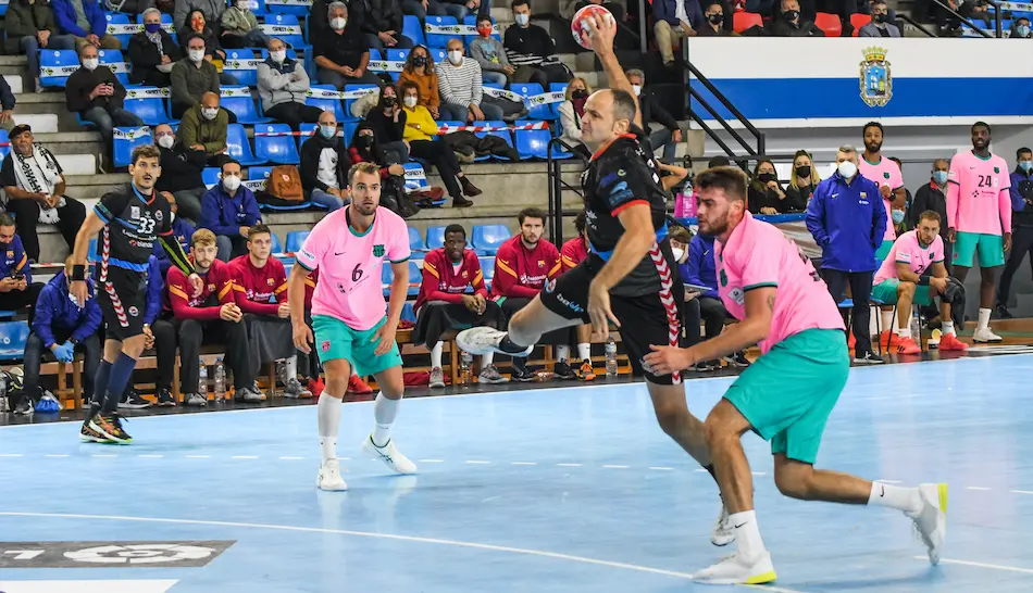 El jugador del Balonmano Sinfin lanza ante un oponente del Bar&ccedil;a. / HARDY