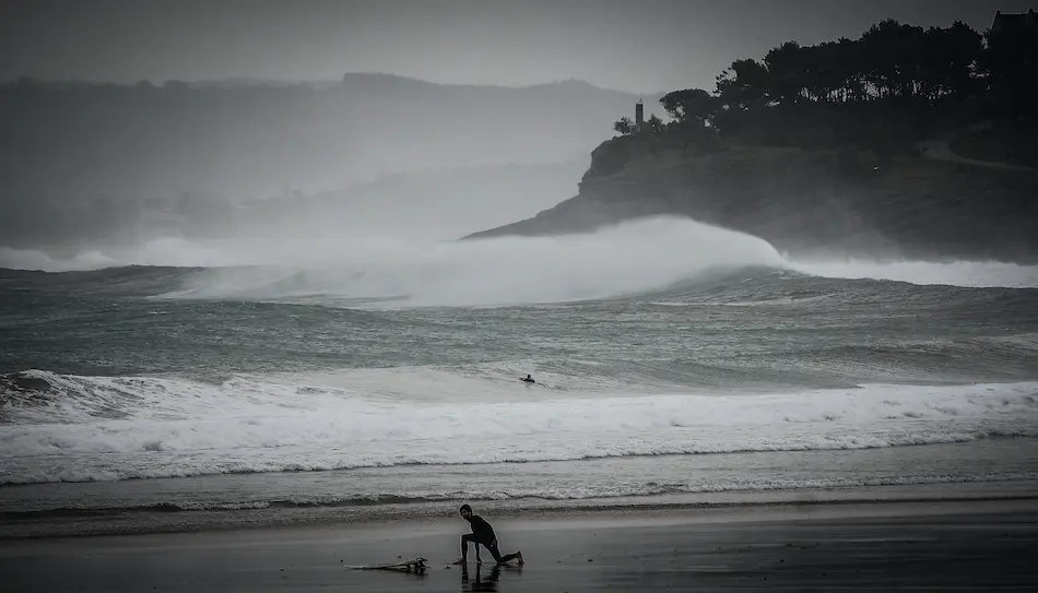 Un surfista en el Sardinero se prepara para hacer deporte en un d&iacute;a en que el temporal &Aacute;lex ha dejado fuertes vientos e importantes lluvias. / HARDY
