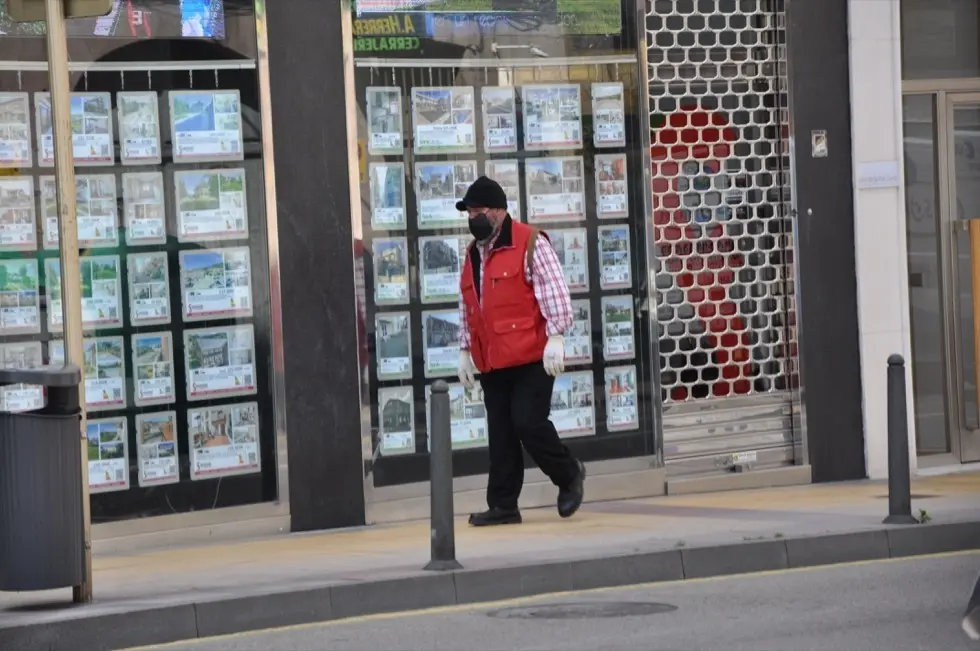 Una persona pasa por delante de un comercio en Torrelavega. / S.D.