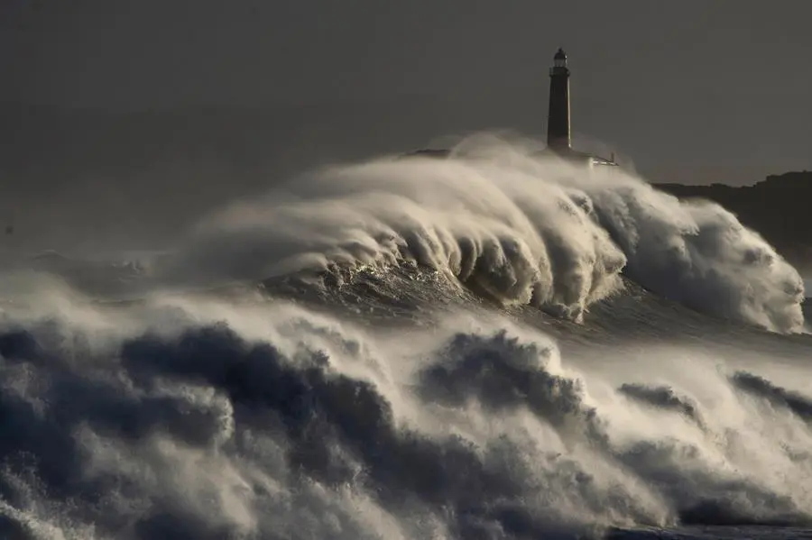 Una ola rompe en el faro de la isla de Mouro el 3 de noviembre en Santander tras el aviso de alerta roja por fen&oacute;menos costeros. EFE/Pedro Puente Hoyos