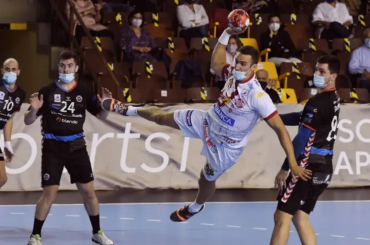 El jugador del Abanca Ademar Drew Donlin (c) lanza ante los jugadore del Sinf&iacute;n Liberbank durante el partido de la octava jornada de la Liga Sacyr ASOBAL disputado hoy en el palacio municipal de deportes de Le&oacute;n. Los jugadores de ambos equipos tuvieron que disputar el encuentro provistos de mascarilla debido a las medidas sanitarias impuestas por la Junta de Castilla y Le&oacute;n para frena la expansi&oacute;n de la pandemia de la cpvid-19. EFE/ J.casares/Foto: J.Casares/EFE