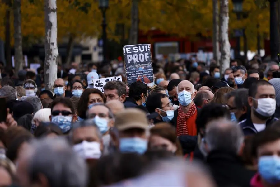 Una persona sostiene un cartel que dice "Soy un maestro" mientras la gente se re&uacute;ne en la Place de la Republique para una manifestaci&oacute;n contra el terrorismo y para presentar sus respetos despu&eacute;s de que el profesor de franc&eacute;s Samuel Paty fuera decapitado, en Par&iacute;s, Francia, el 18 de octubre de 2020.  EFE/EPA/YOAN VALAT