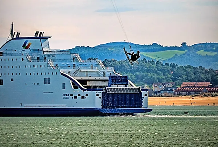 Un 'kitesurfer' practica al paso de un ferry en la bah&iacute;a de Santander, este lunes. EFE/ROM&Aacute;N G. AGUILERA