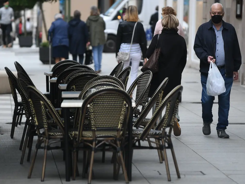 Un persona mira hacia las mesas vac&iacute;as de una cafeter&iacute;a en el Paseo Pereda de Santander. / HARDY