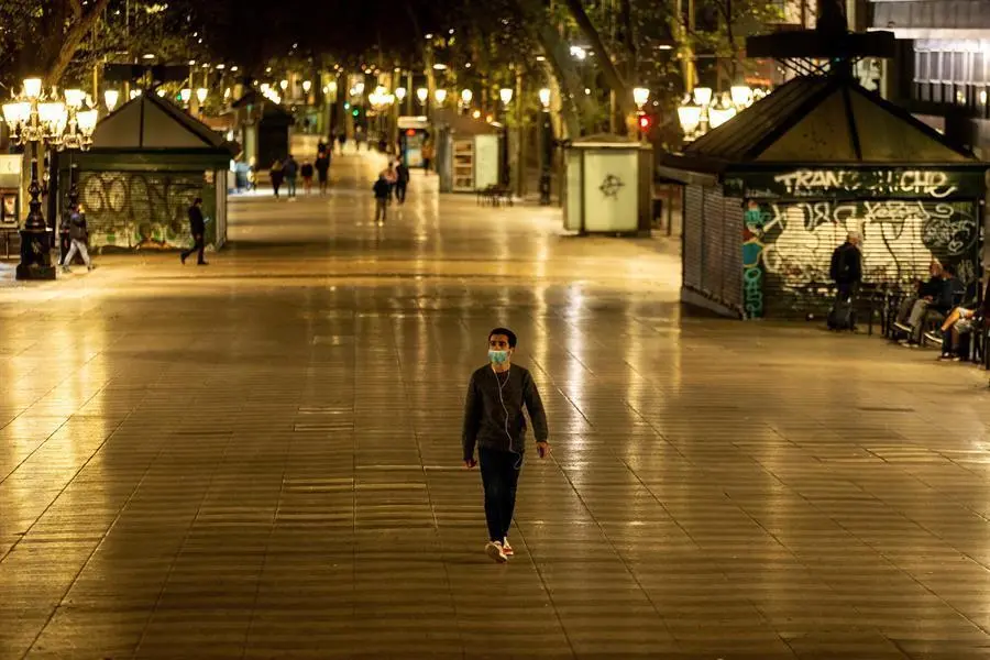 Un hombre pasea hoy domingo por las Ramblas pasadas las 22h, hora decretada por el Gobierno de la Generalitat como inicio del confinamiento nocturno hasta las 6h. El Gobierno de Espa&ntilde;a ha decretado el estado de alarma desde las 11pm. a las 6 am. para todo el territorio nacional, con posibilidad de peque&ntilde;as modificaciones aplicadas por los gobiernos auton&oacute;micos. EFE/Enric Fontcuberta