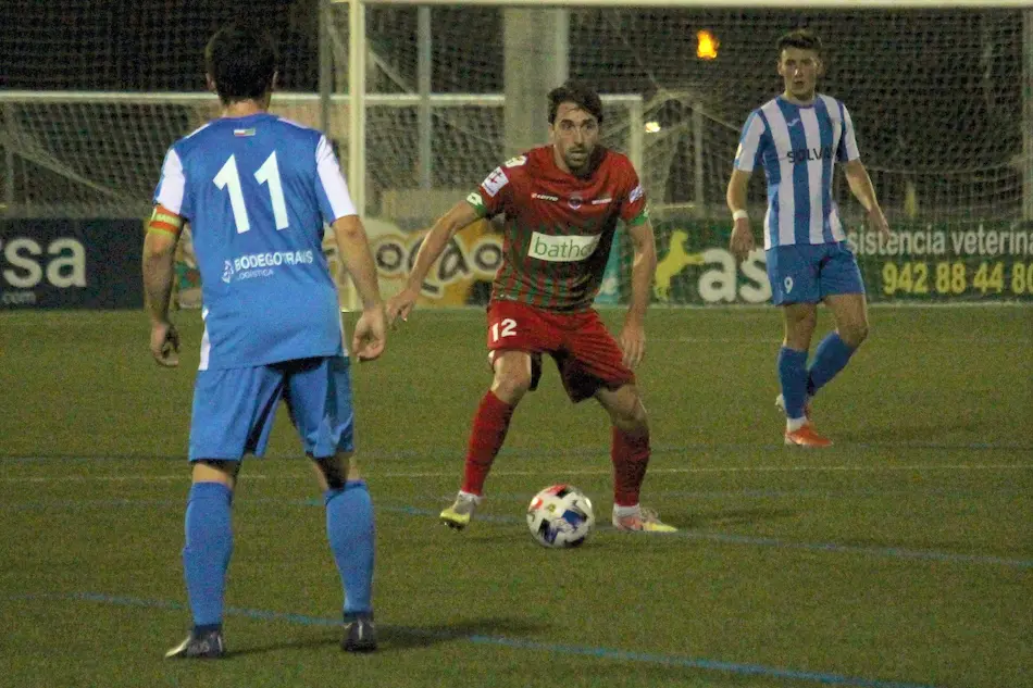 El jugador de la Gimn&aacute;stica retiene el bal&oacute;n ante los jugadores del Barreda.