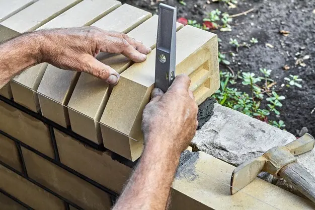 ladrillos-nivelacion-albanil-nueva-cerca-ladrillos-revestimiento-usando-nivel-construccion_98862-1115