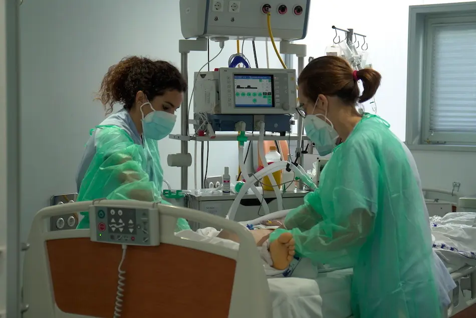 Dos sanitarios atienden en la UCI (Unidad de Cuidados Intensivos) del Hospital de Valdecilla. / ALERTA