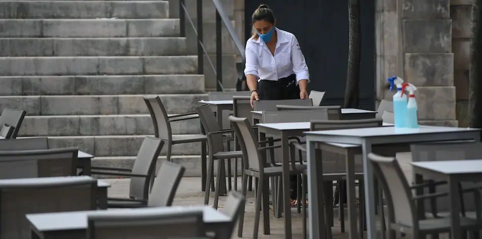 Una trabajadora de la hosteler&iacute;a prepara las mesas antes de empezar la jornada. / Hardy