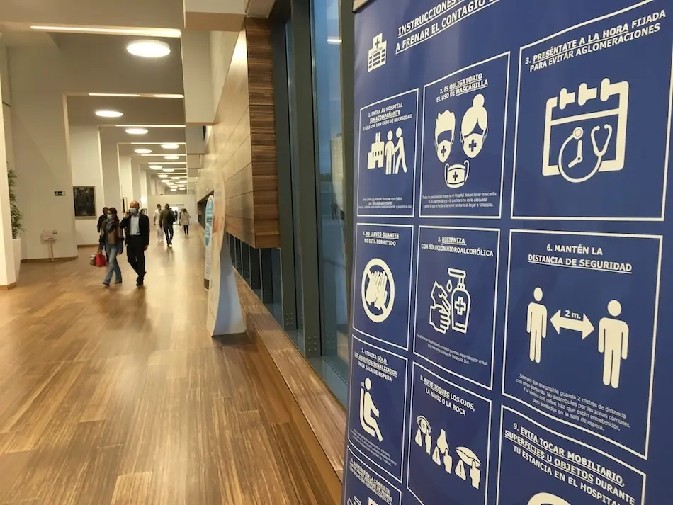 Un cartel con las medidas de prevenci&oacute;n sanitarias en la entrada del Hospital Marqu&eacute;s de Valdecilla. / S.D.