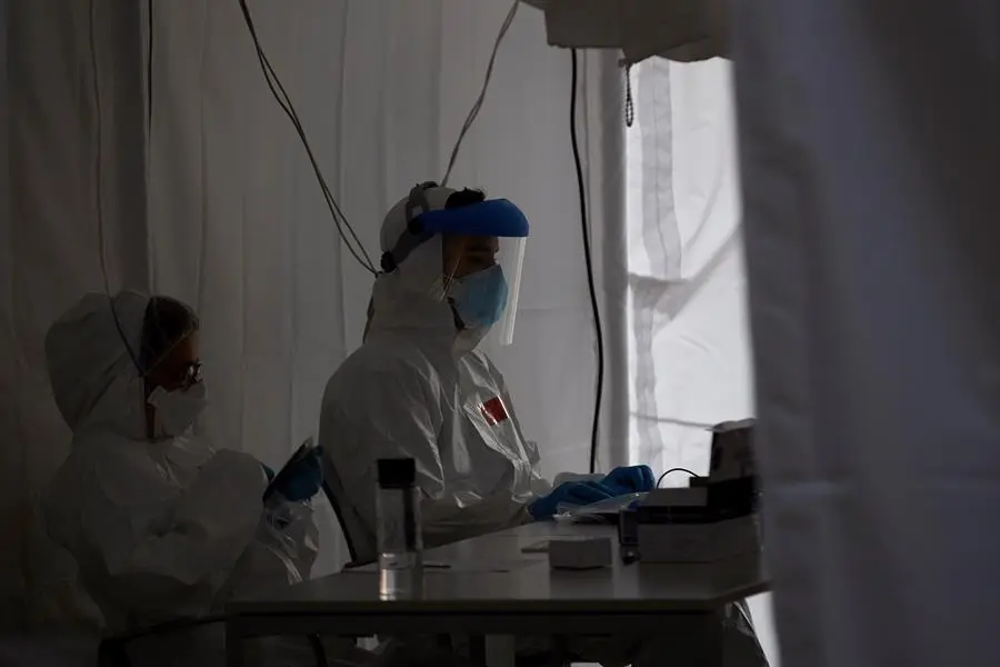Profesionales sanitarios en la carpa provisional para la realizaci&oacute;n de PCR del CAP Roger de Flor de Barcelona, este lunes, cuando la consellera de Salud, Alba Verg&eacute;s, ha subrayado que Catalu&ntilde;a va "por el buen camino" porque se ha superado "el pico de la curva epidemiol&oacute;gica", aunque no se ha doblegado en cambio en el &aacute;mbito asistencial, por la situaci&oacute;n de ocupaci&oacute;n de las UCI, lo que aconseja una desescalada con "prudencia". EFE/Alejandro Garc&iacute;a
