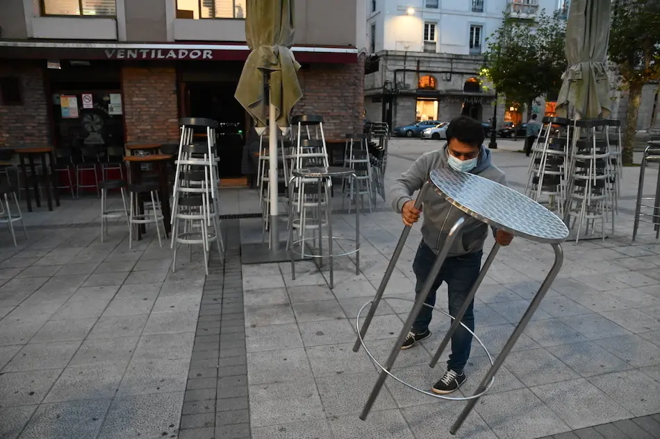 Un trabajador de la hosteler&iacute;a coloca las mesas para iniciar su jornada en la Plaza de Ca&ntilde;ad&iacute;o de Santnader. / HARDY