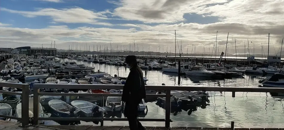 Una persona de avanzada edad camina frente a Puertochico en Santander. / S.D.