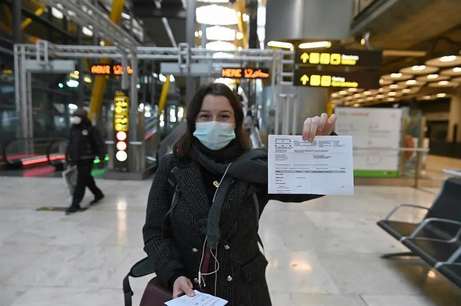 Una joven muestra el resultado de su PCR a su llegada al aeropuerto Adolfo Su&aacute;rez-Barajas en Madrid, este lunes, donde comienza la exigencia de pruebas PCR para pasajeros de vuelos procedentes de pa&iacute;ses de riesgo. Las medidas que entran este lunes en vigor se suman a los controles que se llevan a cabo actualmente a todos los pasajeros internacionales en los puntos de entrada, de tal manera que se mantiene el control de temperatura, el control visual y el control documental, seg&uacute;n la normativa establecida por el Ministerio de Sanidad.Los aeropuertos, adem&aacute;s, seguir&aacute;n recordando por megafon&iacute;a y con carteles luminosos la necesidad de llevar mascarilla y de cumplir las medidas higi&eacute;nicas requeridas por las autoridades sanitarias. EFE/ Fernando Villar