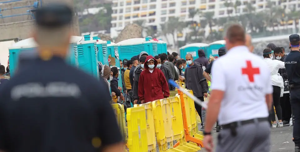 Varios inmigrantes aguardan este martes en el muelle de Arguinegu&iacute;n. / EFE