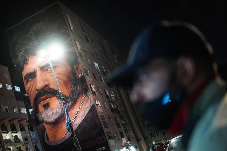 La gente rinde homenaje al ex jugador de f&uacute;tbol argentino y ex jugador del Napoli Diego Maradona cerca del mural de Jorit en San Giovanni al Teduccio, un distrito de la zona este de N&aacute;poles, Italia, el 25 de noviembre de 2020. Diego Maradona ha muerto despu&eacute;s de un ataque card&iacute;aco, informan los medios reclamado el 25 de noviembre de 2020. (Atentado, Italia, N&aacute;poles) EFE / EPA / CESARE ABBATE
