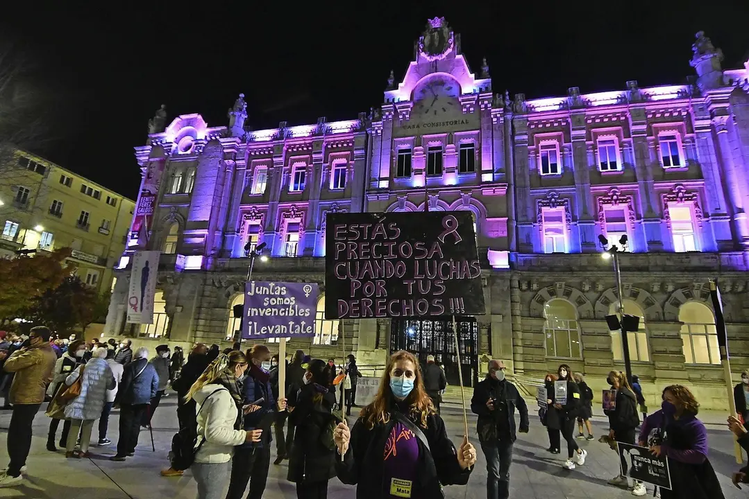 Una mujer con una pancarta anoche ante el consistorio santanderino. / Hardy