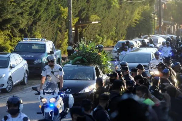 Decenas de hinchas caminan detr&aacute;s del cortejo f&uacute;nebre que traslada los restos de Diego Armando Maradona desde la Plaza de Mayo al cementerio hoy, en Buenos Aires (Argentina). El cortejo f&uacute;nebre que trasladar&aacute; los restos de Diego Armando Maradona hacia un cementerio de la periferia de Buenos Aires comenz&oacute; su marcha a las 17.50 hora local (20.50 GMT) de este jueves, en medio de una Buenos Aires convulsionada por los incidentes entre fan&aacute;ticos del exfutbolista y la polic&iacute;a. El destino final es el cementerio privado Jard&iacute;n Bella Vista, a unos 40 kil&oacute;metros de la capital argentina. EFE/ ENRIQUE GARCIA MEDINA