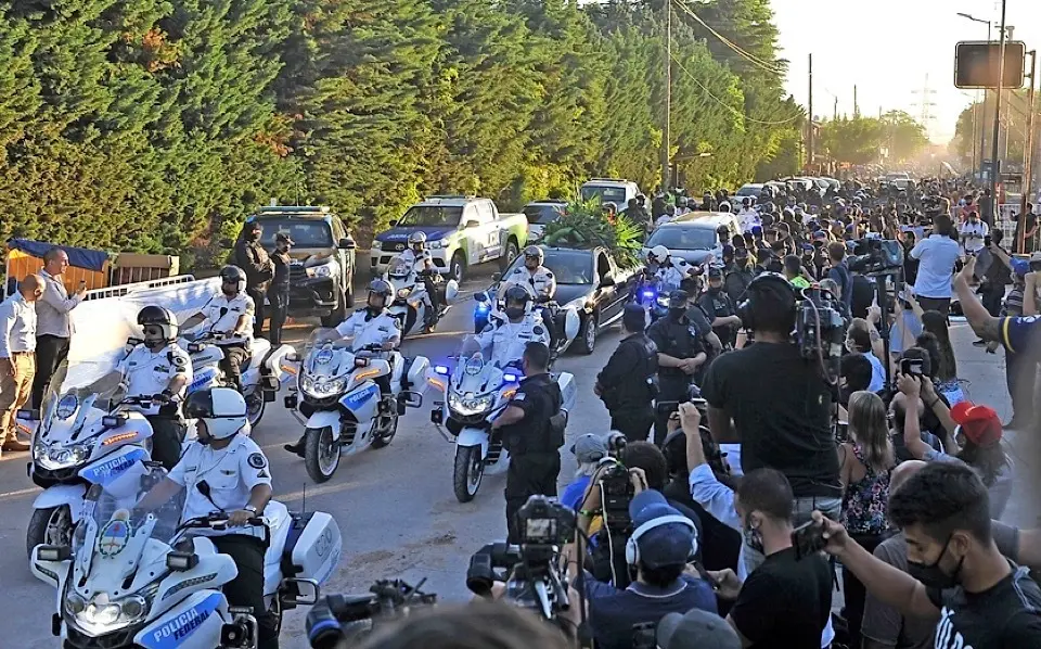 AME1215. BUENOS AIRES (ARGENTINA), 26/11/2020.- Decenas de hinchas caminan detr&aacute;s del cortejo f&uacute;nebre que traslada los restos de Diego Armando Maradona desde la Plaza de Mayo al cementerio hoy, en Buenos Aires (Argentina). El cortejo f&uacute;nebre que trasladar&aacute; los restos de Diego Armando Maradona hacia un cementerio de la periferia de Buenos Aires comenz&oacute; su marcha a las 17.50 hora local (20.50 GMT) de este jueves, en medio de una Buenos Aires convulsionada por los incidentes entre fan&aacute;ticos del exfutbolista y la polic&iacute;a. El destino final es el cementerio privado Jard&iacute;n Bella Vista, a unos 40 kil&oacute;metros de la capital argentina. EFE/ ENRIQUE GARCIA MEDINA