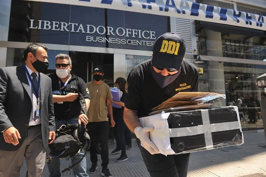 Varios polic&iacute;as salen con documentaci&oacute;n de la cl&iacute;nica del m&eacute;dico de Maradona. / EFE