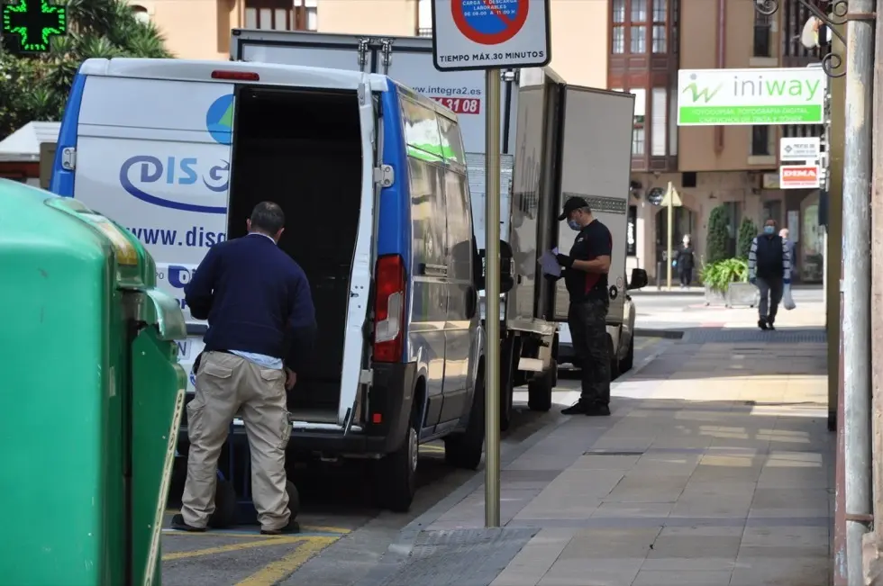 Varios trabajadores de reparto estacionados en una calle en Torrelavega. / S.D.