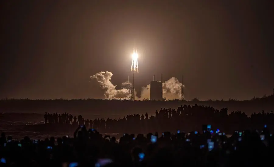 Una multitud observa el lanzamiento de la sonda espacial Chang'e-5 en Wenchang, China, este martes. China lanz&oacute; hoy con &eacute;xito a la Luna la sonda espacial Chang'e-5 para recolectar muestras del sat&eacute;lite y posteriormente regresar a la Tierra, en la primera misi&oacute;n de este tipo desde la d&eacute;cada de 1970. El lanzamiento tuvo lugar a las 04.30 hora local (20.30 GMT) mediante el cohete portador Larga Marcha-5 desde el centro de lanzamiento de Wenchang, en la provincia insular de Hainan, en el sur del pa&iacute;s. EFE/EPA/STR
