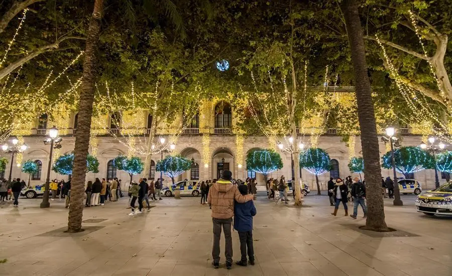 Varias personas disfrutan del encendido navide&ntilde;o en el centro de Sevilla, este s&aacute;bado. La iluminaci&oacute;n navide&ntilde;a de la ciudad de Sevilla ha sido por sorpresa a las 18.30 horas de este s&aacute;bado, como pretend&iacute;a el Ayuntamiento de Sevilla para evitar aglomeraciones en torno al encendido por el coronavirus. EFE/ Ra&uacute;l Caro