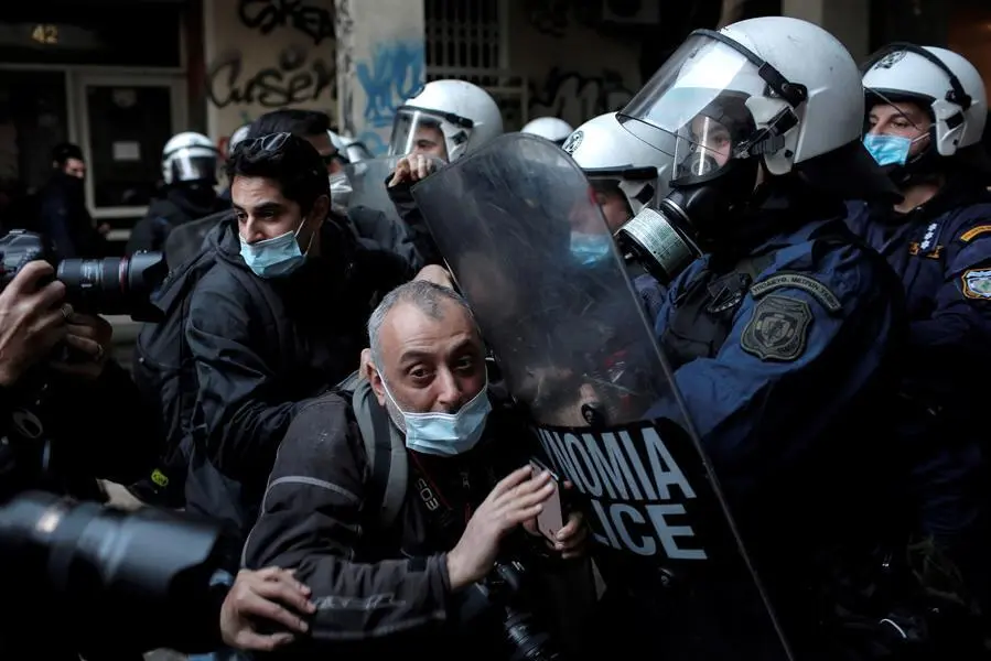 Los agentes de polic&iacute;a hacen retroceder a los fot&oacute;grafos de un sitio donde los manifestantes permanecen atrapados en un edificio durante una operaci&oacute;n policial de vigilancia de una manifestaci&oacute;n que marca el 12 &deg; aniversario del asesinato del adolescente Alexis Grigoropoulos, en Atenas, Grecia, el 6 de diciembre de 2020. Grigoropoulos, 15 a&ntilde;os -viejo estudiante, fue asesinado el 6 de diciembre de 2008 en un aparente tiroteo policial en el centro de Atenas, hecho que provoc&oacute; disturbios en la capital griega. Se esperaban protestas a pesar de la prohibici&oacute;n actual de las reuniones. (Protestas, Grecia, Atenas) EFE / EPA / KOSTAS TSIRONIS