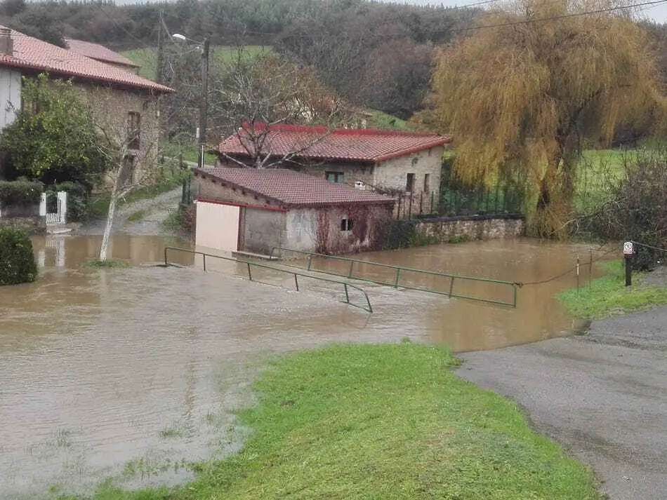 Desbordamiento del r&iacute;o Herrero a su paso por el barrio La F&aacute;brica en Galizano. / ALERTA