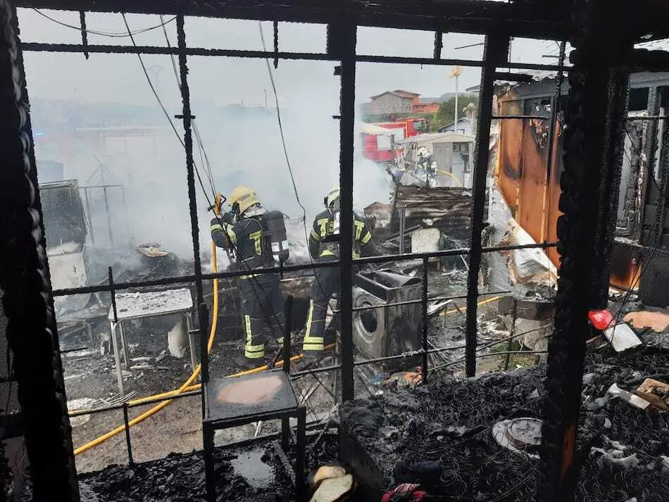 Vista de los trabajos de los bomberos en el incendio camping Ajo.