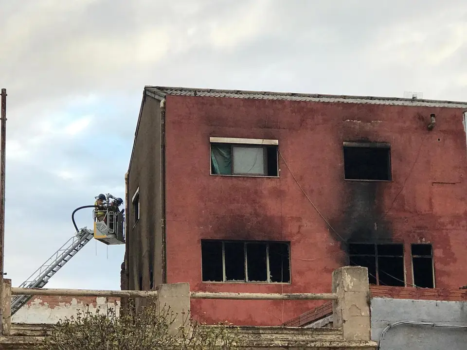 Trabajos de extinci&oacute;n del incendio de una nave en Badalona