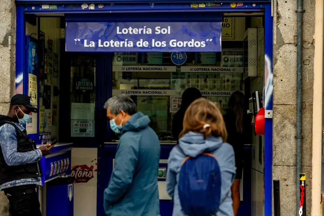 Varias personas hacen cola en las inmediaciones de la administraci&oacute;n de loter&iacute;a. / E. PRESS