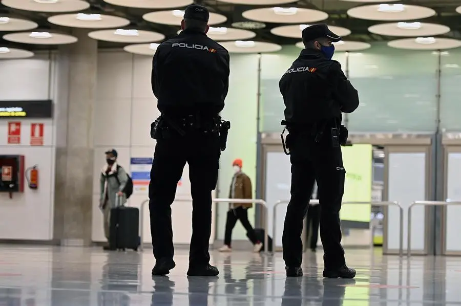 La polic&iacute;a vigila la zona de llegadas de pasajeros en el aeropuerto Adolfo Su&aacute;rez Madrid Barajas este lunes. El Gobierno espa&ntilde;ol anunci&oacute; que reforzar&aacute; el control de verificaci&oacute;n de pruebas PCR a los viajeros procedentes del Reino Unido, con el que hay programados 201 vuelos, en puertos y aeropuertos, despu&eacute;s de que se haya detectado all&iacute; una nueva variante del coronavirus, m&aacute;s contagiosa. EFE/ Fernando Villar