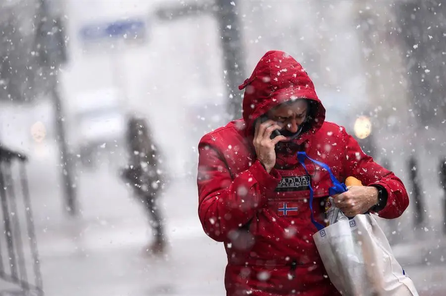 Un hombre camina por una calle de Reinosa, este lunes en la comunidad c&aacute;ntabra donde la Agencia Estatal de Meteorolog&iacute;a mantiene activada la alerta por nevadas./Pedro Puente Hoyos/ ARCHIVO