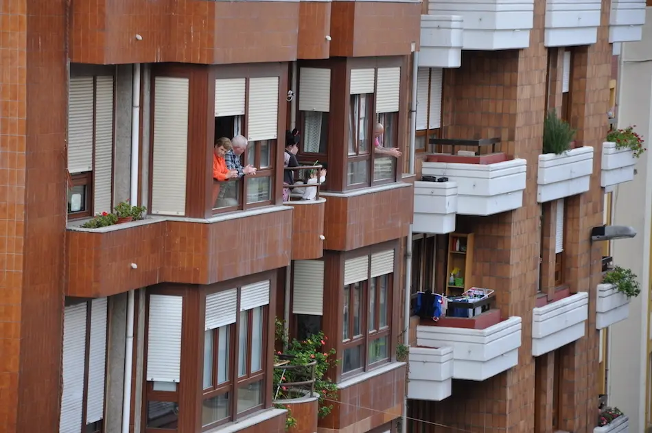 Varias personas en la ventana de sus casas en la calle Joaqu&iacute;n Cay&oacute;n de Torrelavega. / S.D.
