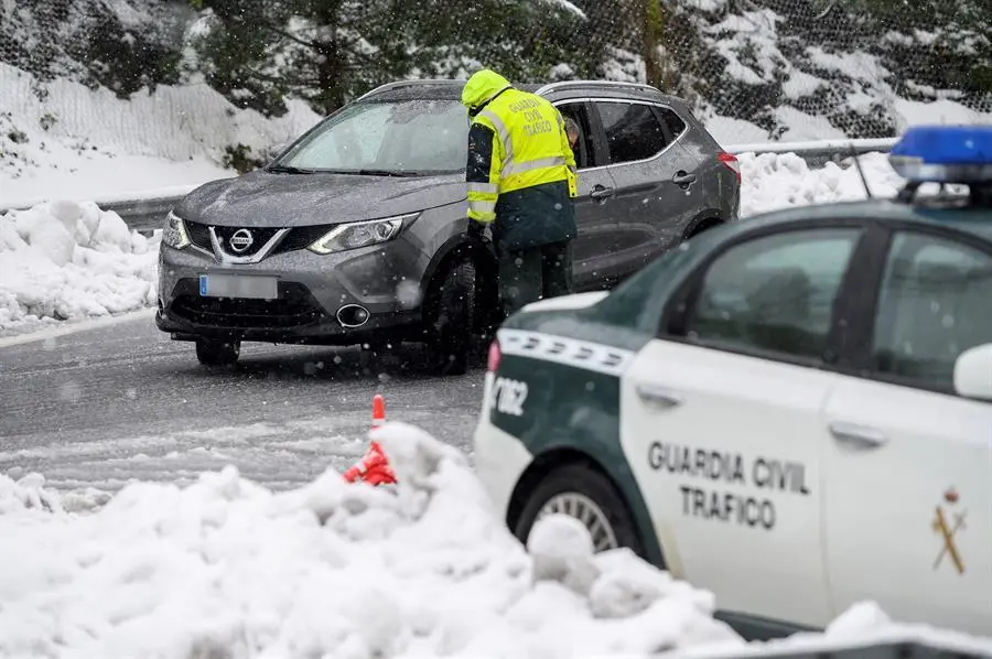 GRAF5035. ARENAS DE IGU&Ntilde;A (CANTABRIA), 04/01/2021.- Agentes de la Guardia Civil cortan el tr&aacute;fico este lunes en la localidad c&aacute;ntabra de Arenas de Igu&ntilde;a debido a las fuertes nevadas. La A-67 en Cantabria se ha cerrado al tr&aacute;fico para veh&iacute;culos pesados por la nieve y los turismos han de circular con cadenas o neum&aacute;ticos de invierno, mientras que adem&aacute;s en la regi&oacute;n est&aacute;n bloqueados seis puertos. EFE/ Pedro Puente Hoyos