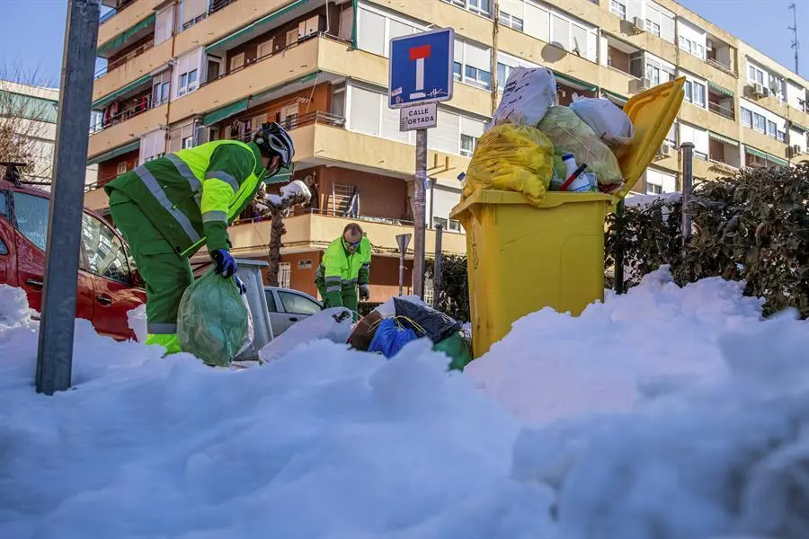 Operarios del servicio de limpieza retiran los cubos de basura de las calles de Madrid tras reiniciarse ayer el servicio de recogida suspendido tras el paso de la borrasca Filomena. EFE/Rodrigo Jim&eacute;nez.