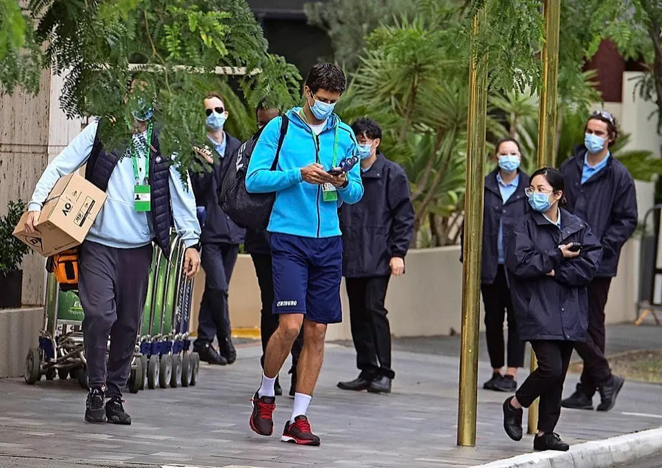 El tenista brasile&ntilde;o Marcelo Melo es escoltado desde su habitaci&oacute;n de hotel hasta la pista de entrenamiento en Melbourne. / EFE
