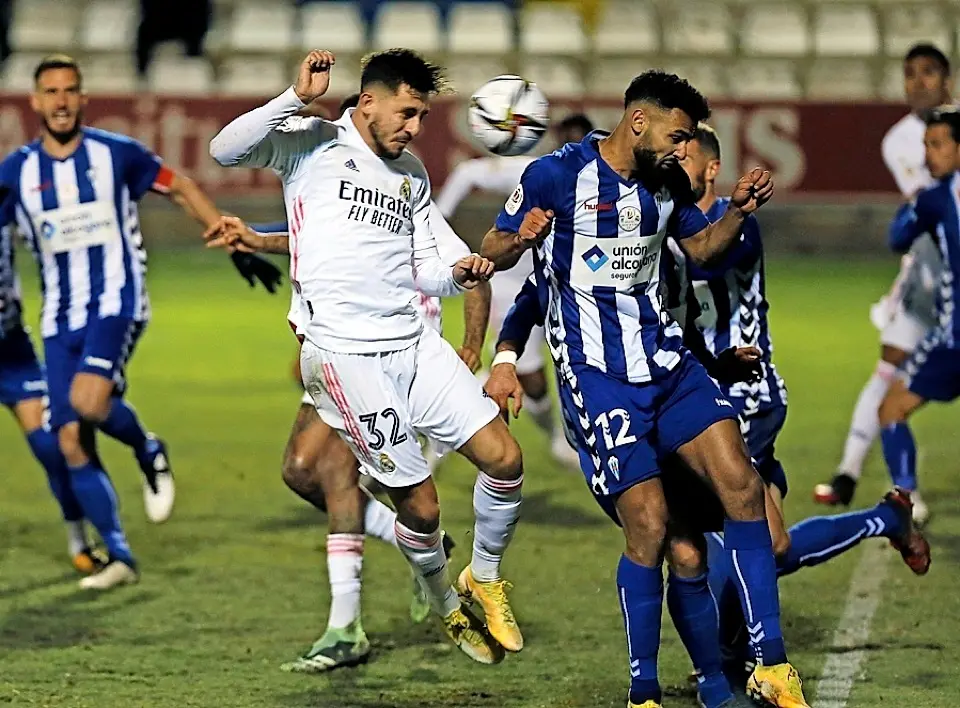 GRAF4321. ALCOY (ALICANTE), 20/01/2021.- El defensa del Real Madrid V&iacute;ctor Chust (i) cabecea un bal&oacute;n ante Mourad El Ghezouani, del Alcoyano, durante el partido de dieciseisavos de final de la Copa del Rey que disputan este mi&eacute;rcoles en el estadio El Collao, en Alcoy (Alicante). EFE/Manuel Lorenzo