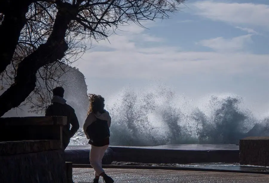 Hortensia, la borrasca atl&aacute;ntica que desde ayer afecta a todo el pa&iacute;s, se encamina ya m&aacute;s atenuada hacia el este peninsular, aunque en su trayectoria ha dejado rachas huracanadas de 179 kil&oacute;metros por hora, olas de m&aacute;s de 7 metros en el litoral atl&aacute;ntico e intensas lluvias en el oeste peninsular. En la imagen, dos personas pasean por la zona tur&iacute;stica de Camp de Mar. EFE/CATI CLADERA