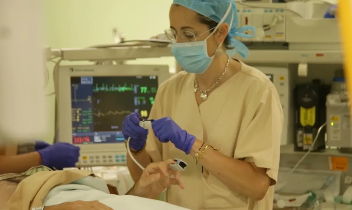 Una sanitario del Hospital Marqu&eacute;s de Valdecilla atiende a paciente. / TREVOL