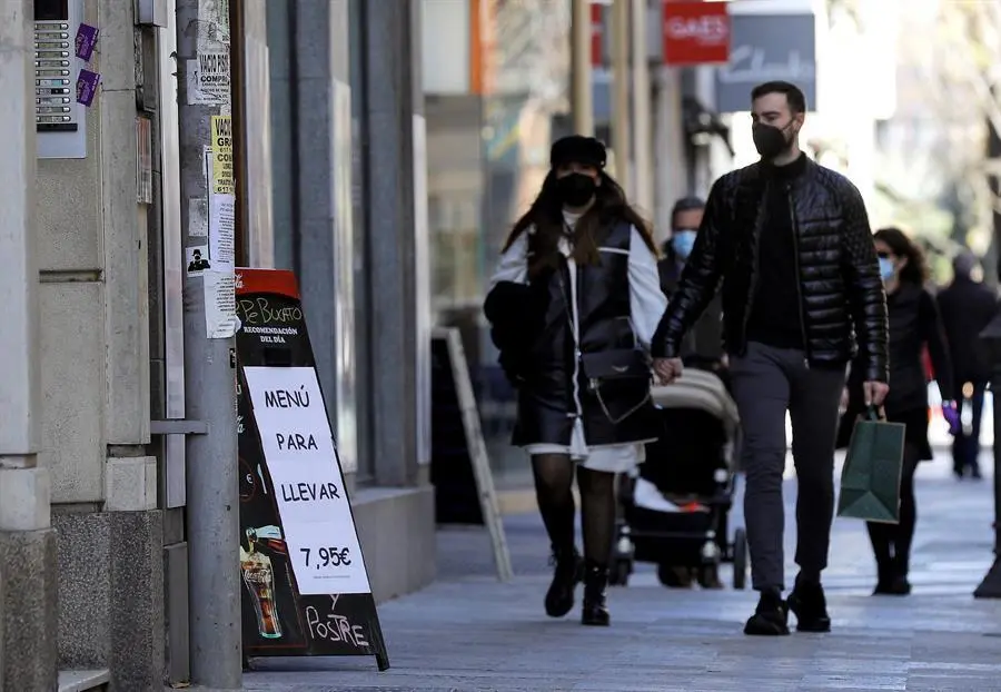 Apostar por la comida a domicilio se ha convertido en un recurso de algunos hosteleros para mantener la actividad y reducir p&eacute;rdidas mientras est&eacute; en vigor el cierre establecido por el Gobierno valenciano, un camino que ya iniciaron en oto&ntilde;o como ayuda para pagar gastos y para el que han dise&ntilde;ado men&uacute;s espec&iacute;ficos que resulten atractivos a los clientes. En la imagen varias personas pasan, este domingo, ante un restaurante que muestra su carta y sus men&uacute;s para llevar. EFE/Manuel Bruque