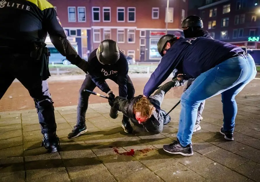 Un hombre es reducido por varios polic&iacute;as durante los distubios registrados anoche en Rotterdam, Pa&iacute;ses Bajos. EFE/EPA/MARCO DE SWART