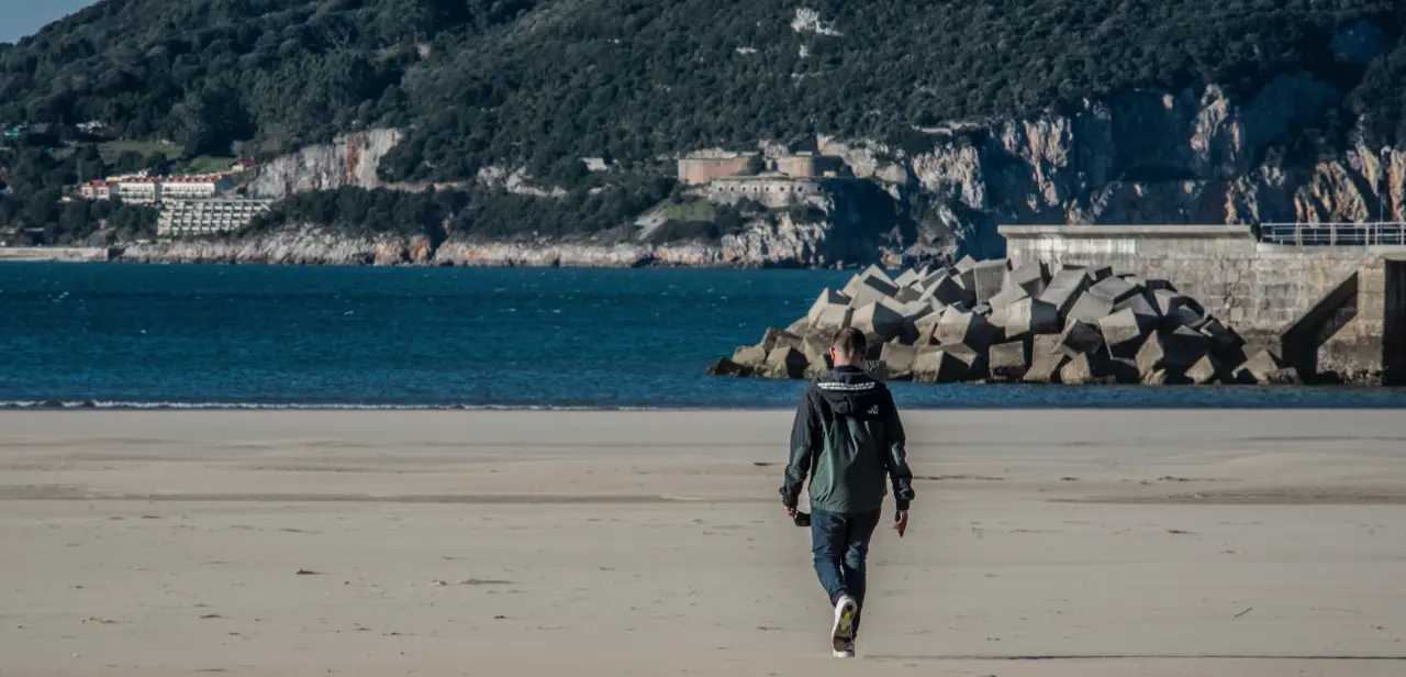 Un j&oacute;ven pasea por la playa de Laredo muicipio que quedar&aacute; confnado desde las 00.00 de ma&ntilde;ana. / Tono Reguera