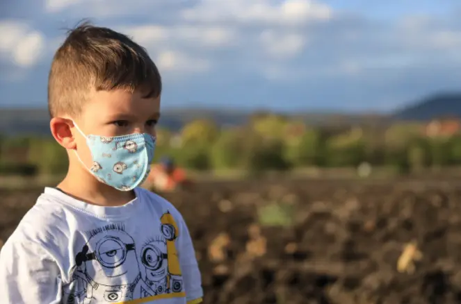 Un ni&ntilde;o con mascarilla en la salida de un colegio.