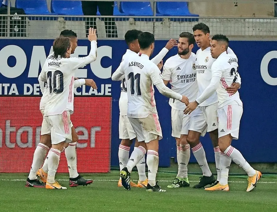HUESCA 06/02/2021.- El defensa franc&eacute;s del Real Madrid Rapha&euml;l Varane (2d) celebra con sus compa&ntilde;eros uno de sus goles ante el Huesca durante el partido de LaLiga que se disputa este s&aacute;bado en el estadio de El Alcoraz de Huesca. EFE/JAVIER CEBOLLADA