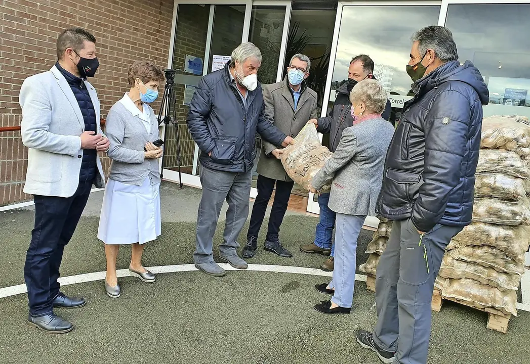 El alcalde de Valderredible y representantes del Ayuntamiento de Torrelavega durante la entrega de las patatas. / ALERTA