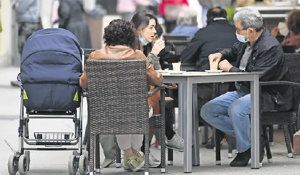Varios ciudadanos con la protecci&oacute;n de la mascarilla en una terraza del centro de Santander. / Hardy