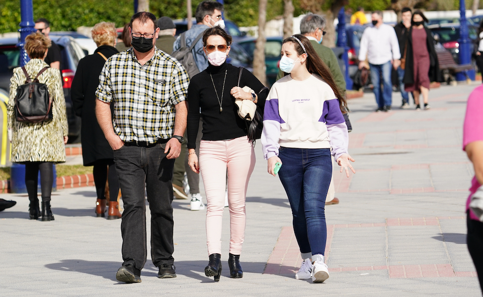 Varias personas con mascarilla caminan por las inmediaciones de la playa del Sardinero en Santander. / Hardy